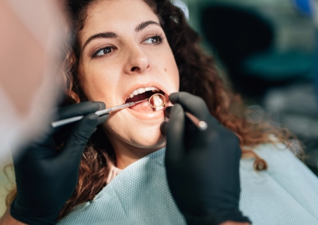 Mulher morena com a boca aberta no dentista