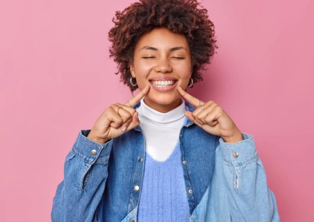 Mulher negra de olhos fechados com um grande sorriso