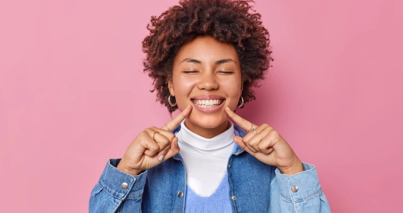 Mulher negra de olhos fechados com um grande sorriso