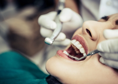 Mulher sorridente sendo atendida em um consultório de dentista